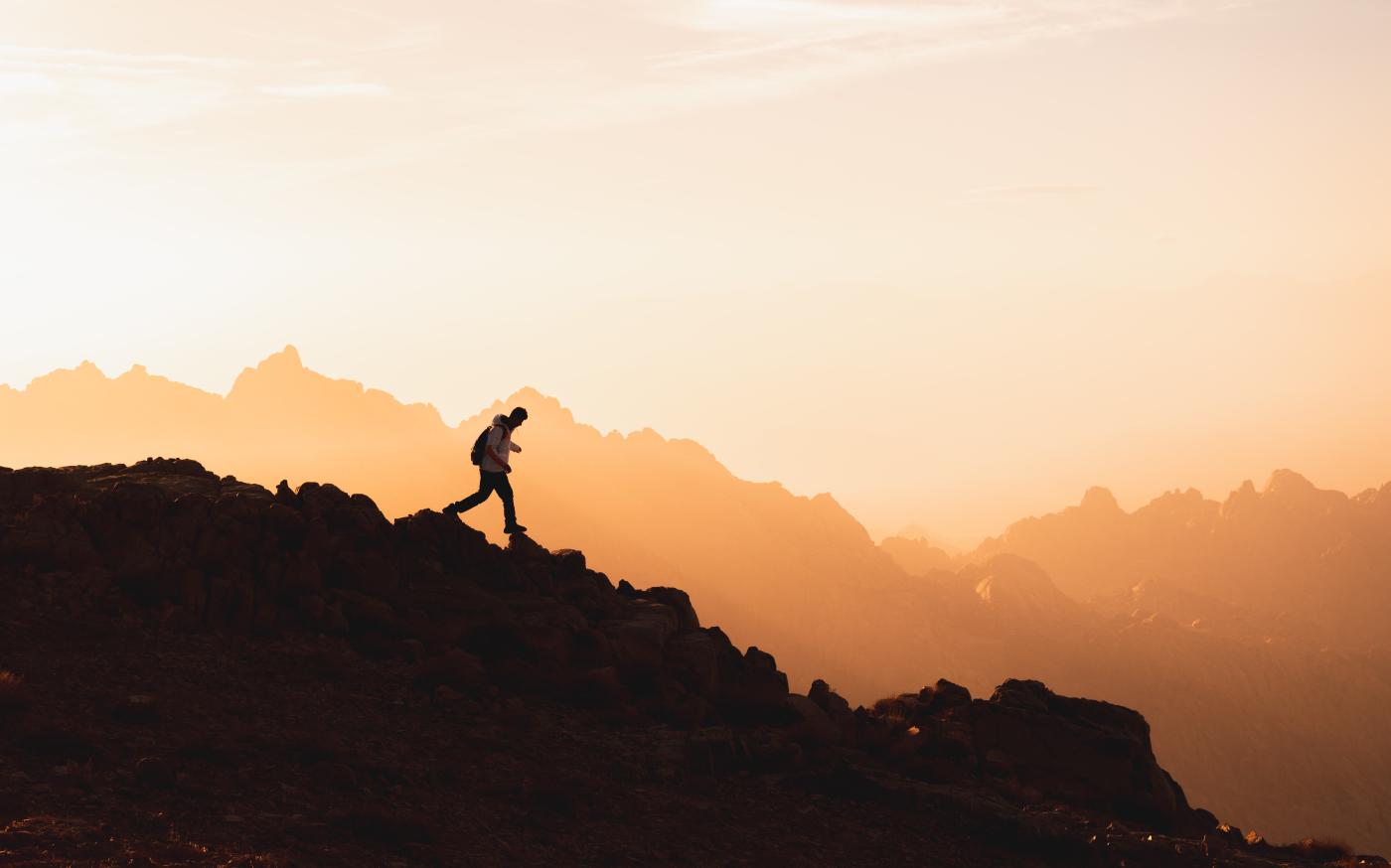 a person standing on top of a mountain by NEOM courtesy of Unsplash.