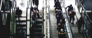 people running up and down escalators