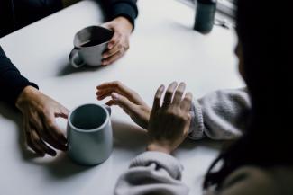 a group of people sitting around a white table by Priscilla Du Preez 🇨🇦 courtesy of Unsplash.